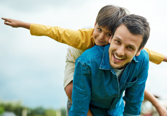 Un père et son fils souriants dans un champ